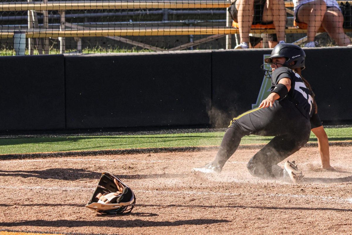 Junior Jodie Epperson supports herself while sliding into home plate, kicking up dirt in the process. A utility player new to WSU softball this year, Epperson played two years for North Texas.