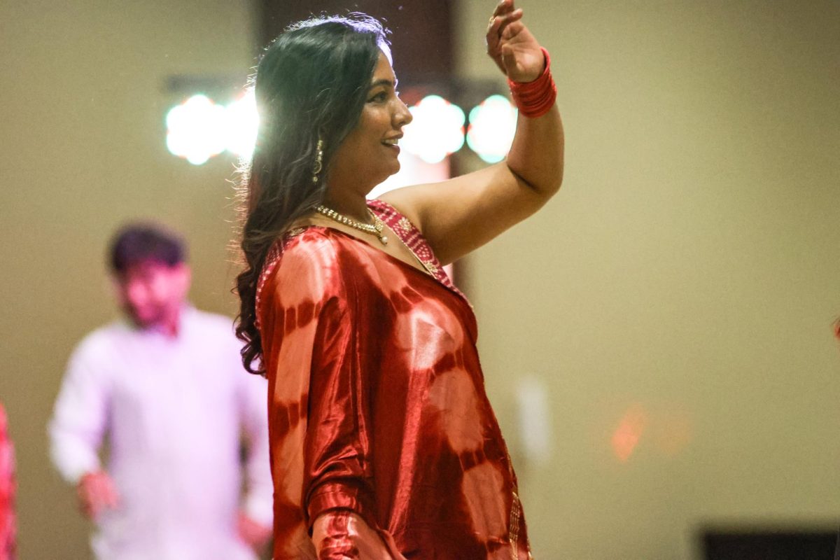 A community member performs the Garba dance, which is typically done at the beginning of the night. The vibrant costumes and swirling movements symbolize the cosmic energy and divine power that connect everyone involved.