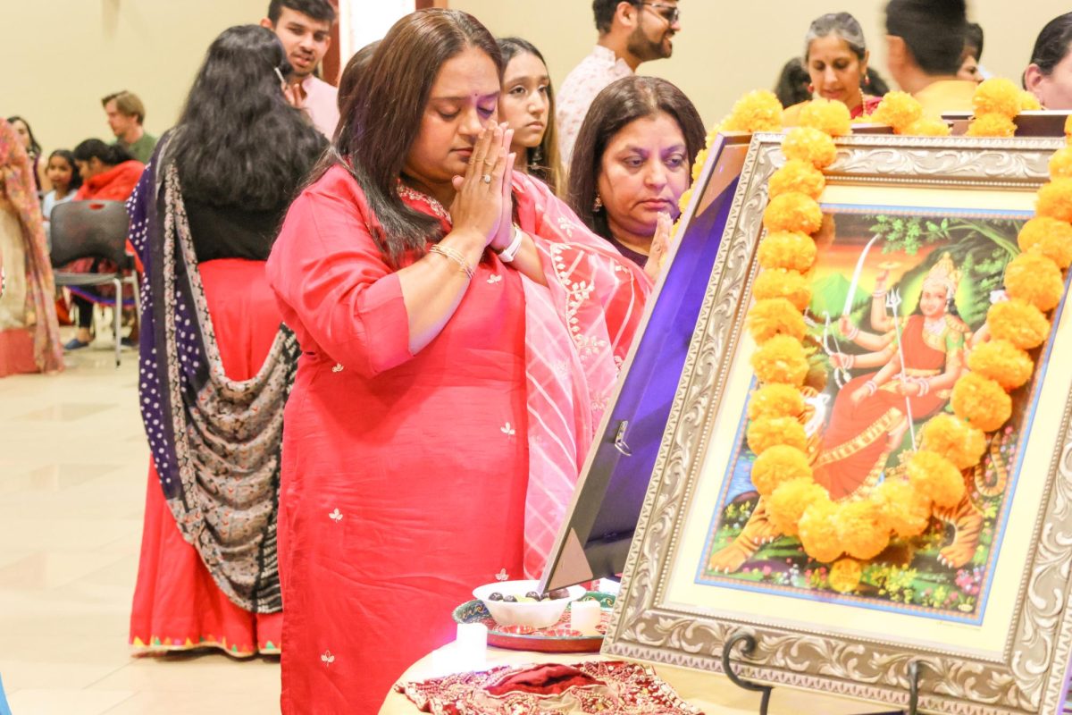 A community member prays to the goddess Durga at the Garba Night celebration on Oct. 5. Praying to Durga, especially during festivals like Navratri, is a way for devotees to connect spiritually.