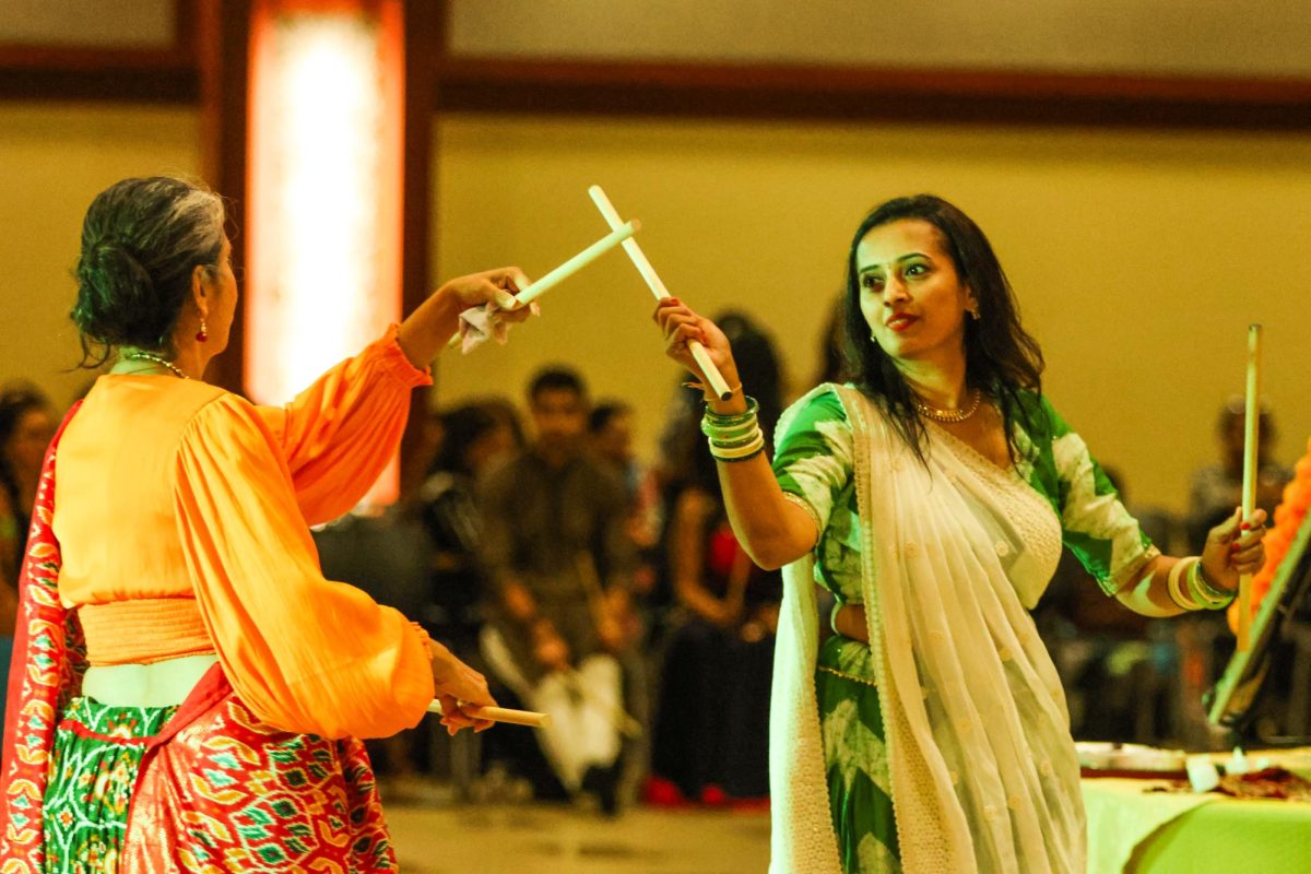 Dipal Brahmbhatt and a community member perform Dandiya Raas. The dance represents a mock fight between goddess Durga and the demon Mahishasura. Each movement in Dandiya reflects strength and celebrates the goddess’s victory over evil.