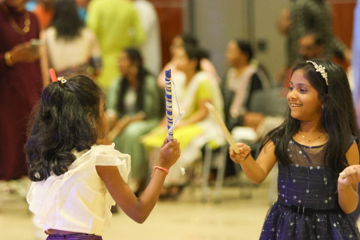 Two children hit sticks together during Dandiya Raas, a tradition passed down through generations. Dandiya Raas is not just a dance; it's a celebration of life, energy and joy.