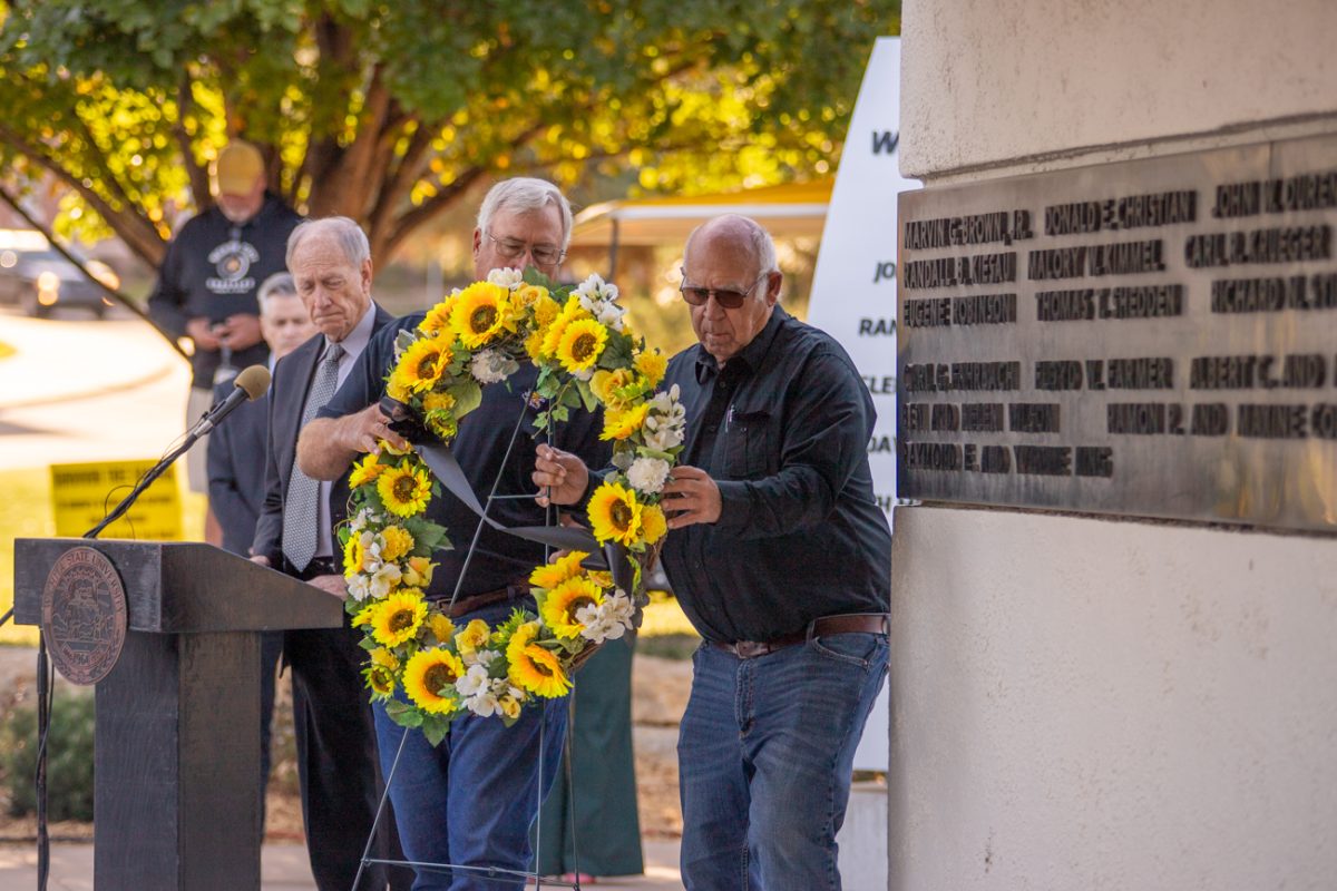 Rick Dvorak and Alan Young place a flower garland to honor the people who lost their lives in the plane crash on Oct. 2, 1970. Families and WSU athletes attended the 54th memorial ceremony on Wednesday morning.