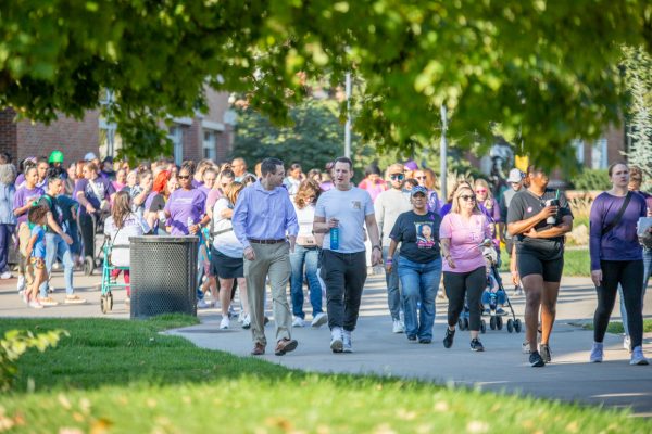 People walk to gather around the Plaza of Heroines on the Wichita State campus during Purple Mile annual domestic violence awareness walk on Oct. 12. The event was hosted by Midwest Criminal Justice Institute, WSU HOPE Services, Wichita Family Crisis Center, and Harbor House.