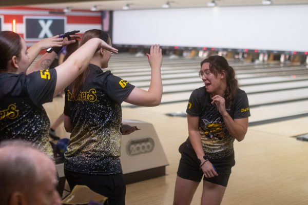 Graduate student Chloe Ciecko dances with her team to celebrate a spare. Ciecko is currently working on a graduate degree in sociology.