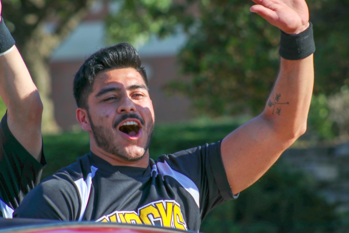 Rafael Guereque waves at attendees as he rides through the streets of the Shocktoberfest Parade. 