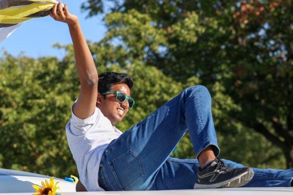 Matthew Neelagandan waves a streamer in the air at the Shocktoberfest Parade on Oct. 5. Neelagandan is an RA at the Suites and rode the Housing and Residence life vehicle.