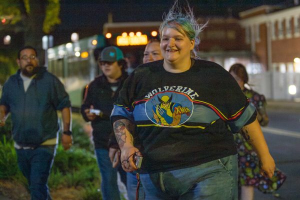 Zelda McAfee beams as they rush back to Ulrich Museum to finish the ghost hunt on Monday, Oct. 21. Attendees first investigated Henrion Hall's basement ceramic area before performing a "ghost box" on the second floor of Ulrich Museum.