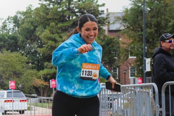 Kaitlyn Sabala grins as she crosses the finish line of the 5K Pumpkin Run race. Sabala was one of more than 450 racers who participated in the annual event.