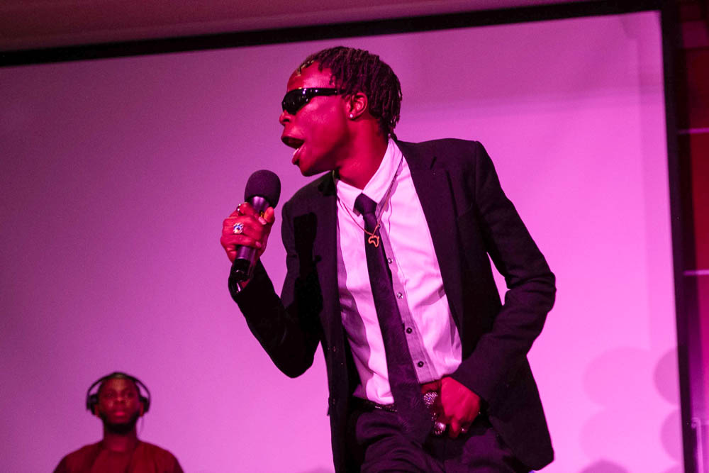 Jeremiah “Jerry” Serugo sings along to Jordan Kayemba's piano playing and a pre-recorded track during the Afro Karibbean Night talent show. After showering the audience in fake $100 bills, Serugo and Kayemba won the contest and took home a gift card prize and praise from the Kelly Matahwa, the "African Queen" and judge of the contest.