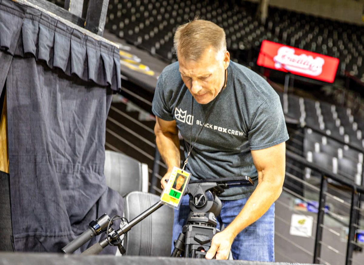 Todd Schwartz sets up a tripod in the stands in front of the pep band at Charles Koch Arena. Schwartz said he typically arrives three hours before a game to set up.