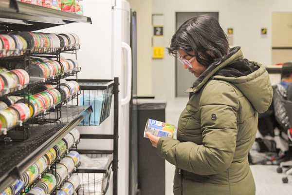 Khushboo Singh looks at items in the Shocker Support Locker. Over winter break, the locker is closed so food will be provided to students on campus through student housing.