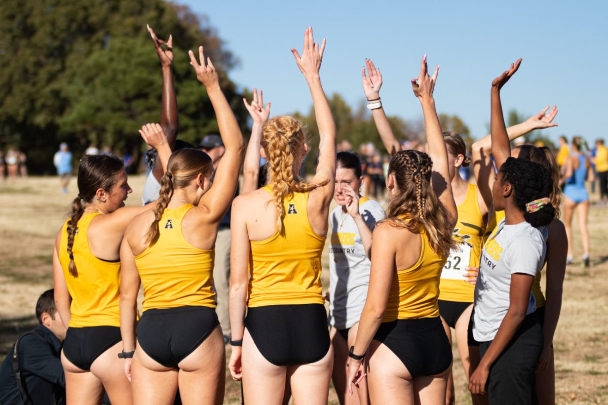 Women's cross country runners hype themselves up for the start of the AAC Cross Country Championship on Nov. 1. The event was held at the L.W. Clapp Memorial Park and included both the mens and women's championship race.