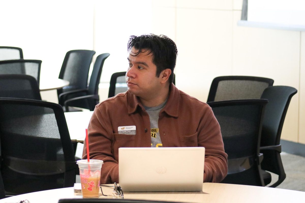 Student Engagement and Belonging student programs coordinator Ivan Castillo listens and takes notes on a computer as the panel members speak Nov. 12.