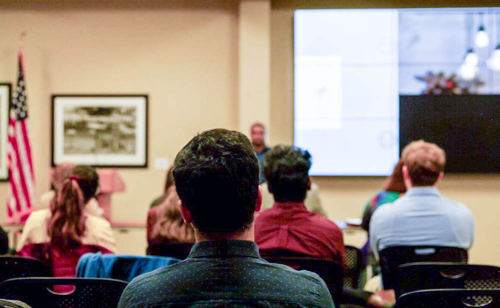 A student sits at the back of the room listening to Chinmay Kulkarni's thesis presentation. His thesis work focused on the need to intertwine renewable energy for more reliable power systems.