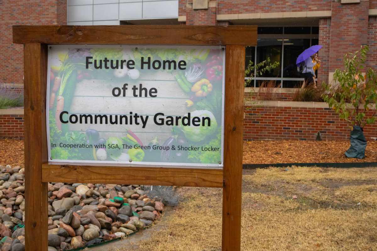 A sign outside of the Rhatigan Student Center announces that the community garden will be re-homed outside the RSC and Shocker Success Center. The garden has been located next to Ahlberg Hall since it was installed in 2020.