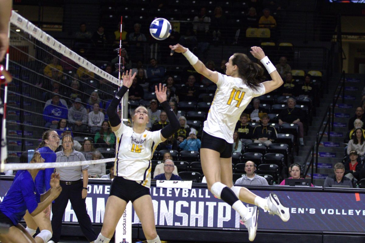 Sophomore middle blocker Maddie Wilson spikes a set by fifth year Izzi Strand against the University of Tulsa. The Friday, Nov. 22, AAC quarterfinal match saw the Shockers walk away victorious, 3-0.