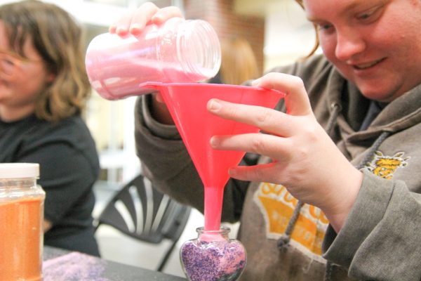 Jay Wyrick participated in the Make and Take Sand Art event during Destress Fest. Wyrick used pink and blue sand to make her "Kuzco's poison".