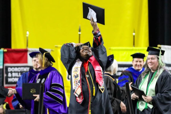 An undergraduate WSU student holds up her degree during the Fall 2024 Commencement ceremony.