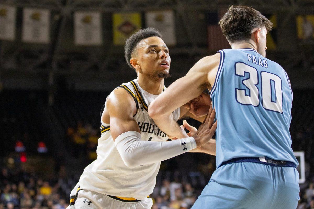 Senior guard Xavier Bell looks to the basket as players attempt to shoot the ball. Bell scored 21 points during the game, but the Shockers ultimately lost 74-64 to the Roos.