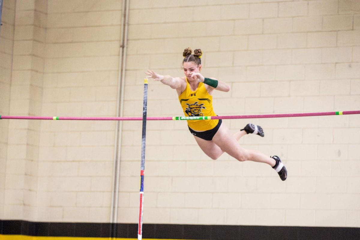 Kylie Scott releases her pole after vaulting over the bar. Scott was on the yellow team during the Black vs Yellow Intrasquad track and field competition on Dec. 6.