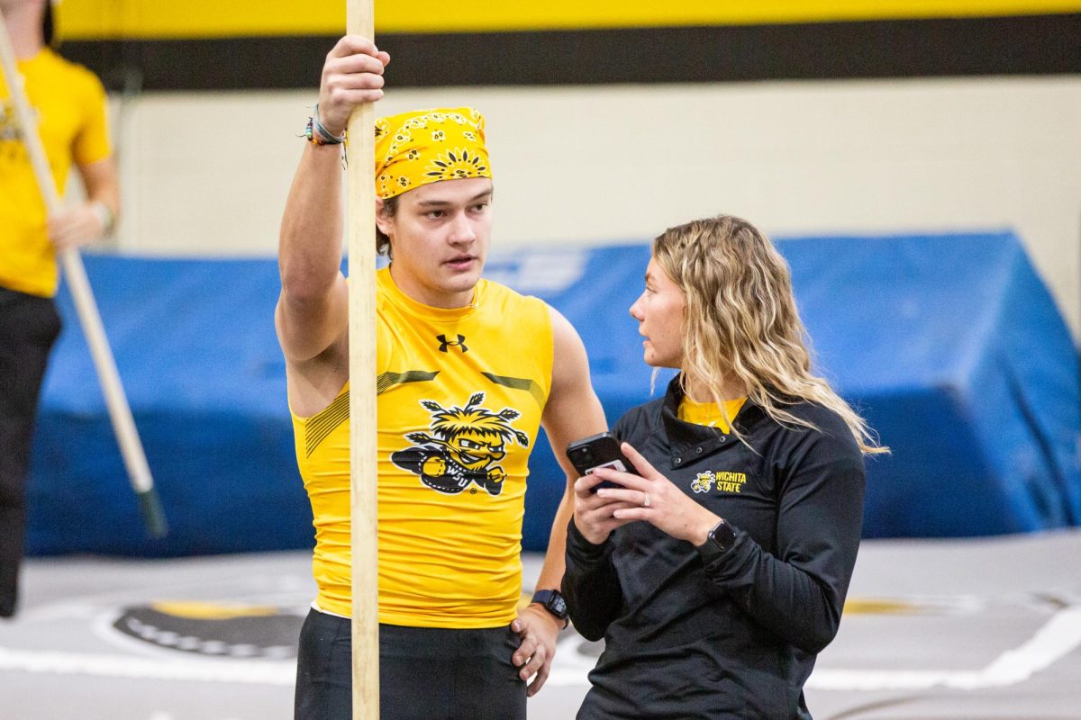 Weston Hulse watches video of his pole vault performance, recorded by Aliyah Fertig, the pole vault coach for track and field.