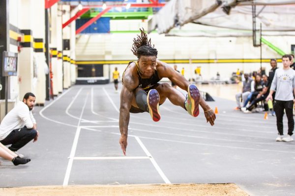 Amarrion Reese leaps forward during the Black vs. Yellow Intrasquad event on Dec. 6.  Reese competes in sprint and jump events for track and field.