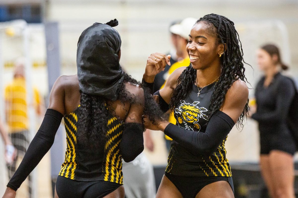 Farrah Miller and Chidera Okoro bump playfully into each other after Miller competed in the high jump. The track and field team competed in the Black vs. Yellow Intrasquad meet on Dec. 6.