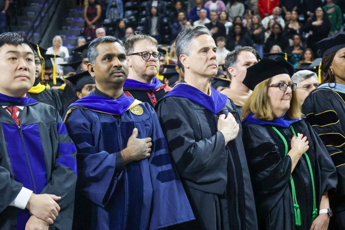 WSU faculty stand with there hand over there heart with the National Anthem. The Anthem was sung by Pulip Han.