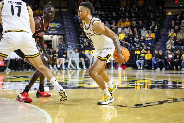 Senior guard Xavier Bell does a behind-the-back dribble move on Dec. 29. Bell finished with a Shocker career-high 29 points in the 87-72 win over Friends.