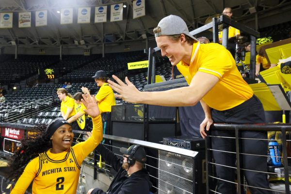 Freshman guard KP Parr high-fives a member of the WSU pep band after the Shockers' win on Dec. 2. Parr played 18 minutes in the game.