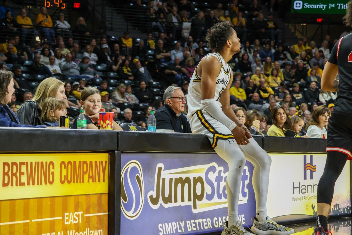 Junior forward Corey Washington sits on the courtside table after losing the ball on Dec. 29. Washington started the game on the bench for the first time this season.