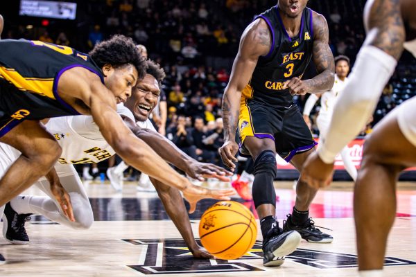 Senior center Quincy Ballard reaches to gain possession of the ball in the first half. Ballard scored 11 points and 10 rebounds in the Jan. 18 game against East Carolina University.