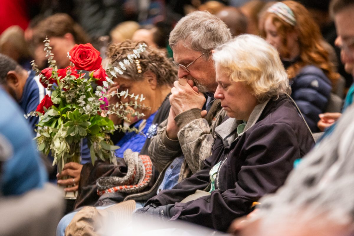 A couple who attended the Jan. 30 vigil for the Flight 5342 crash victims bow their head in prayer. Several local priests, pastors, rabbis and other religious leaders spoke and gave prayers during the Thursday afternoon ceremony.