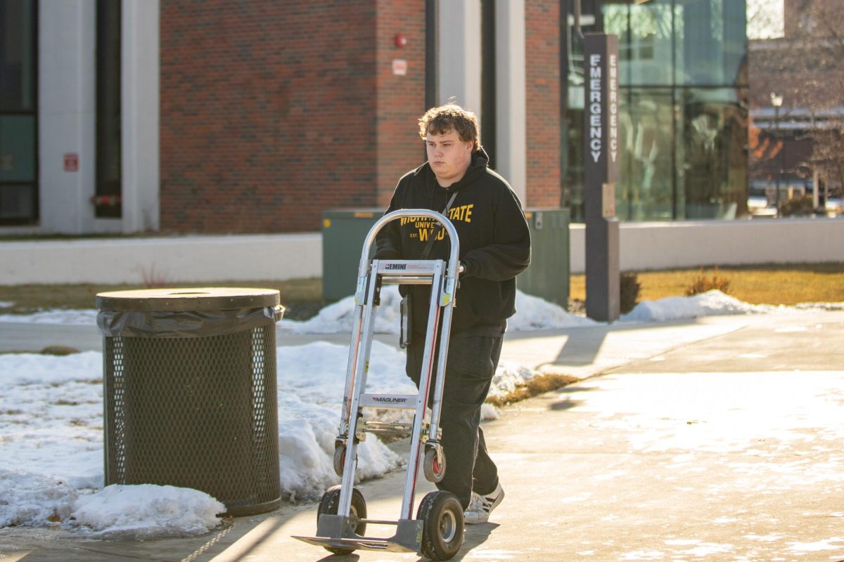 Kyle DeVault wheels a dolly cart around campus on Wednesday, Jan. 22. DeVault delivers items for Shocker Printing Solutions.