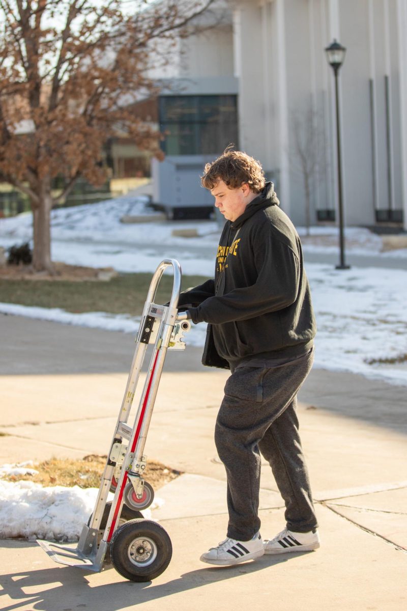 Kyle DeVault wheels a dolly cart around campus on Wednesday, Jan. 22. DeVault delivers items for Shocker Printing Solutions.