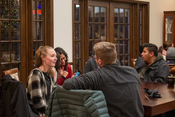 Students mingle inside the President's Residence. Due to the cold weather, attendees had the opportunity to warm up inside and grab some treats.