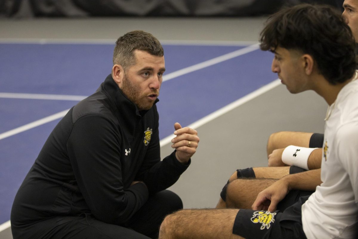 Head men's tennis coach Darragh Glavin talks to Ilias Worthington and Vanja Hodzic between doubles sets on Feb. 26. Worthington and Hodzic won their match, 6-2.