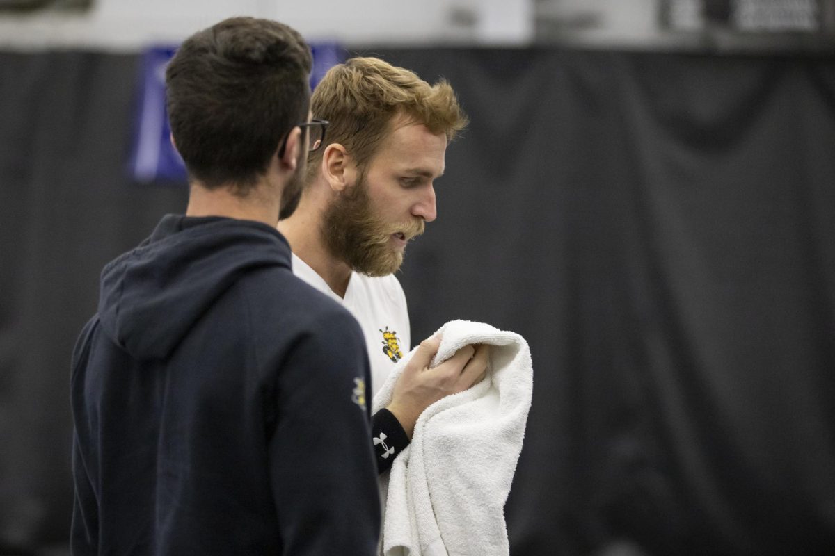 Joan Grosset talks to Kristof Minarik in between singles match sets. Minarik helped Wichita State secure a win over Drake University.