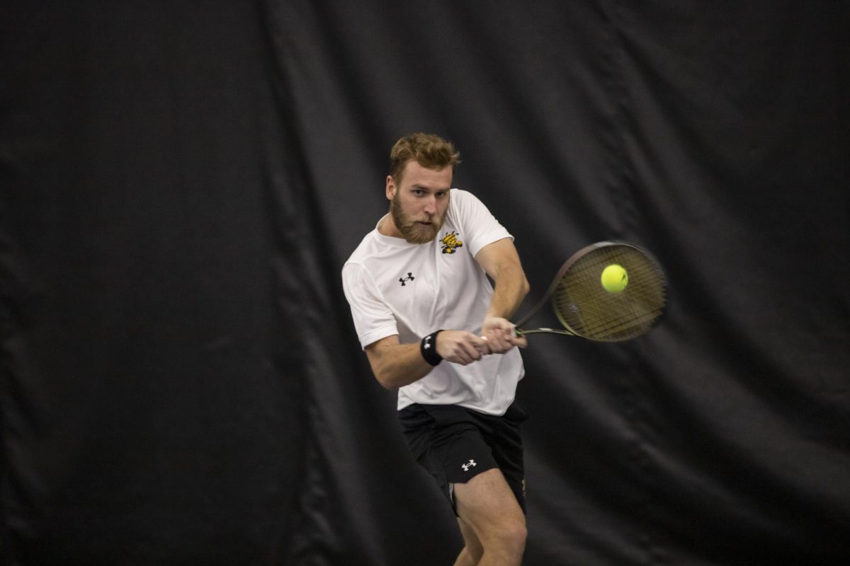 Kristof Minarik sends the ball to a Drake University opponent during a Jan. 26 tennis match.