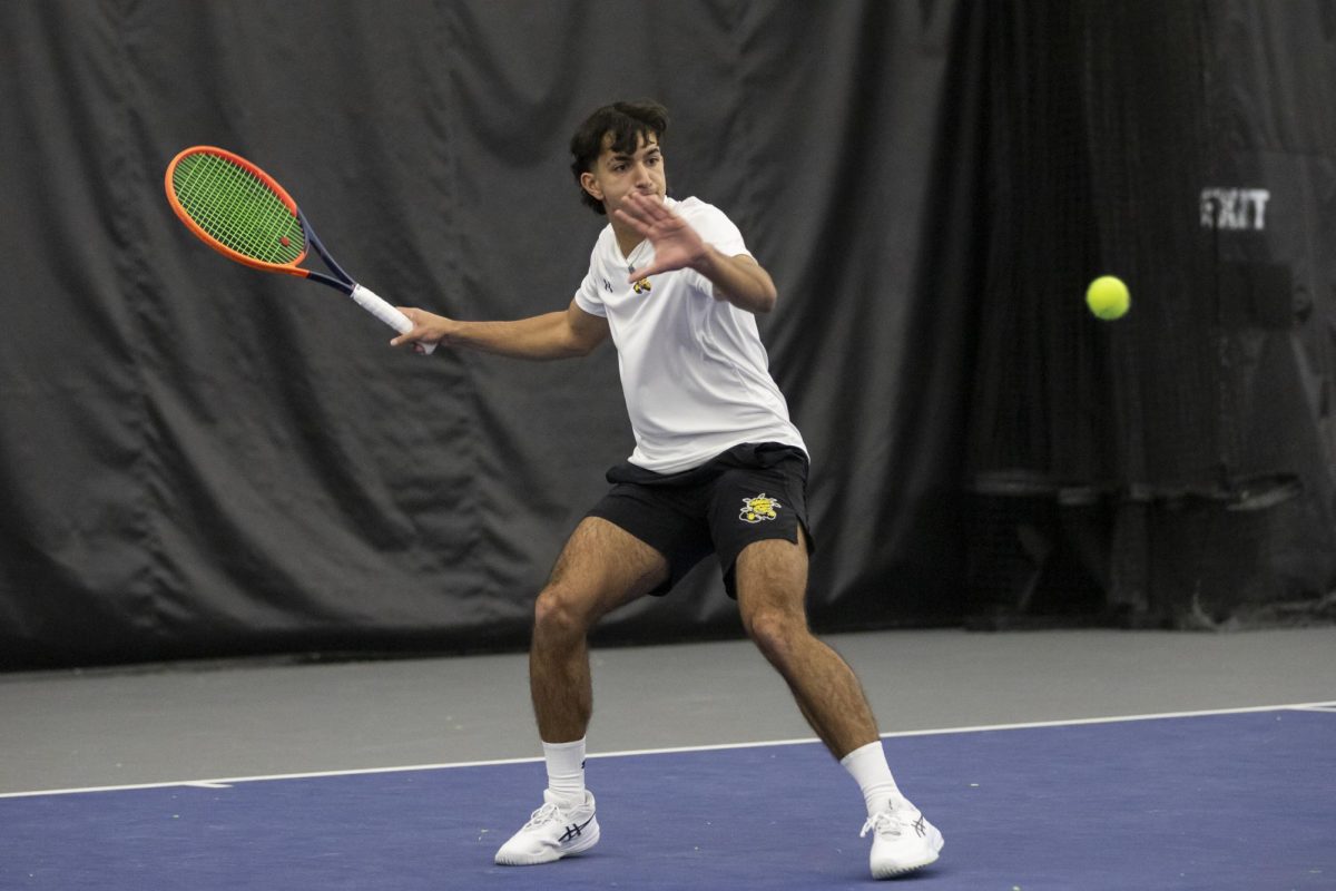 Ilias Worthington prepares to hit the ball during a singles match against a Drake University opponent. Worthington helped Wichita State secure a 7-0 win against the Bulldogs.