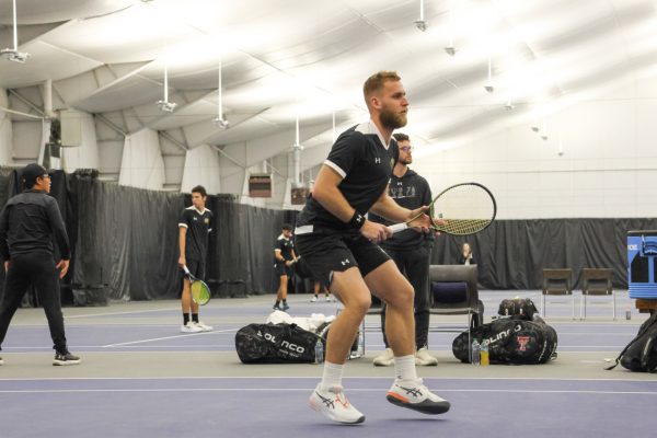 Junior Kristof Minarik keeps his eye on the ball during a match against Texas Tech. He fought hard but fell short in singles, losing 4-3, and in doubles, he and his partner Alejandro Jacome were defeated, 6-1.