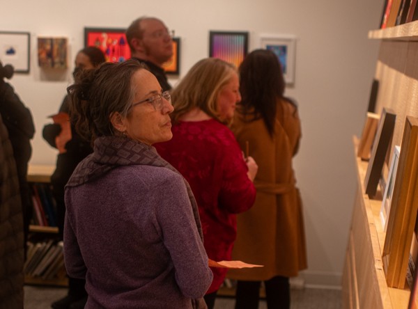 Contributing artist Denise DeBusk looks at art for sale during the "Love Wins" auction on Feb. 13. DeBusk is a local artist, who contributed art to the auction.