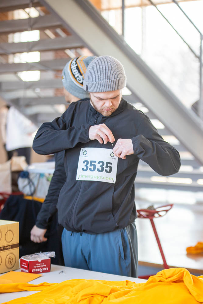 Spencer Merrill, a Wichita State student, fastens his bib to his jacket ahead of the Wichita State Engineering 5K Run/Walk. The annual event raised money for College of Engineering need-based scholarships. Run/Walk. The annual event raised money for College of Engineering need-based scholarships.