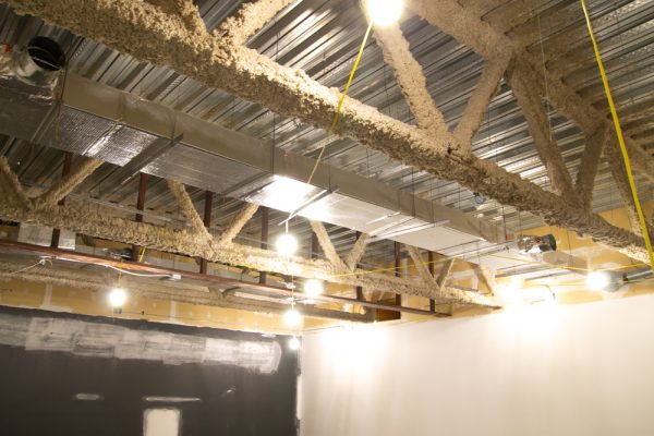 Lights hang by a yellow cord in Linquist 601. The room is under construction while being converted into a book technologies lab.