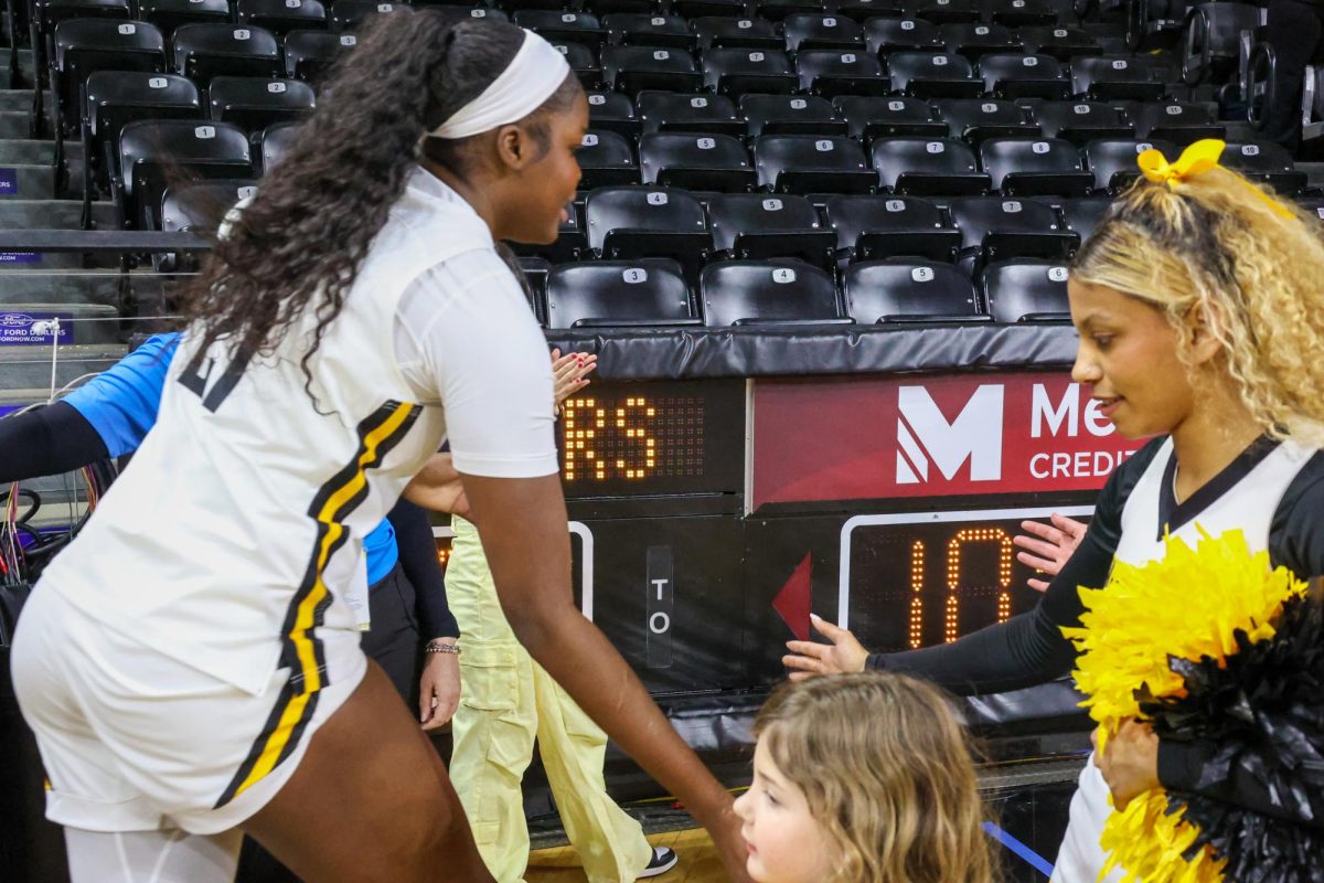 Senior center Aicha Ndour high-fives Wichita State cheerleaders after a 60-57 win against Rice University. Ndour led the team in rebounds with 13 on Feb. 15.