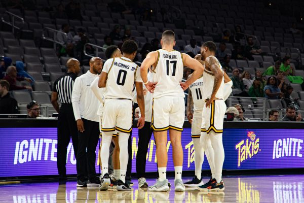 The WSU men's basketball team huddles up to talk to head coach Paul Mills during a short break in play. The game on March 13 was played at Dickies Arena in Fort Worth, Texas.