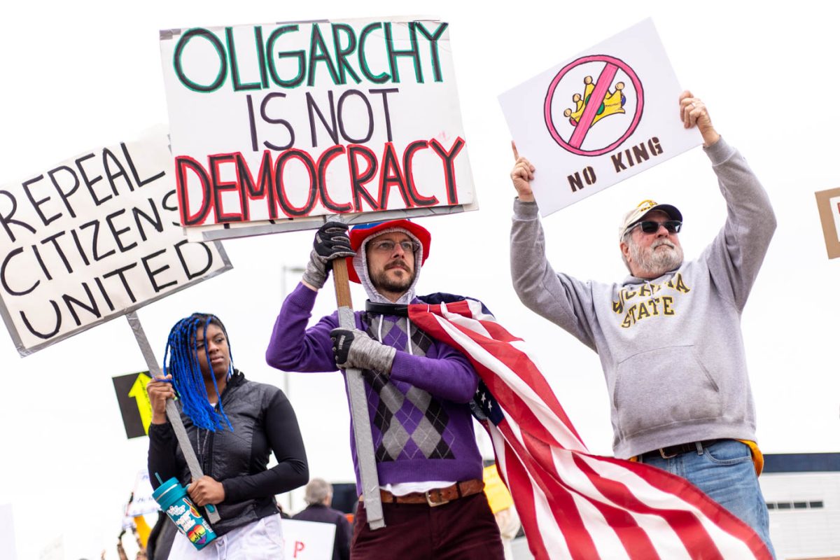 Grace Outwater and Mark Barlow hold signs during the March 3 protest. Barlow is a former Wichita State Student Government senator. 