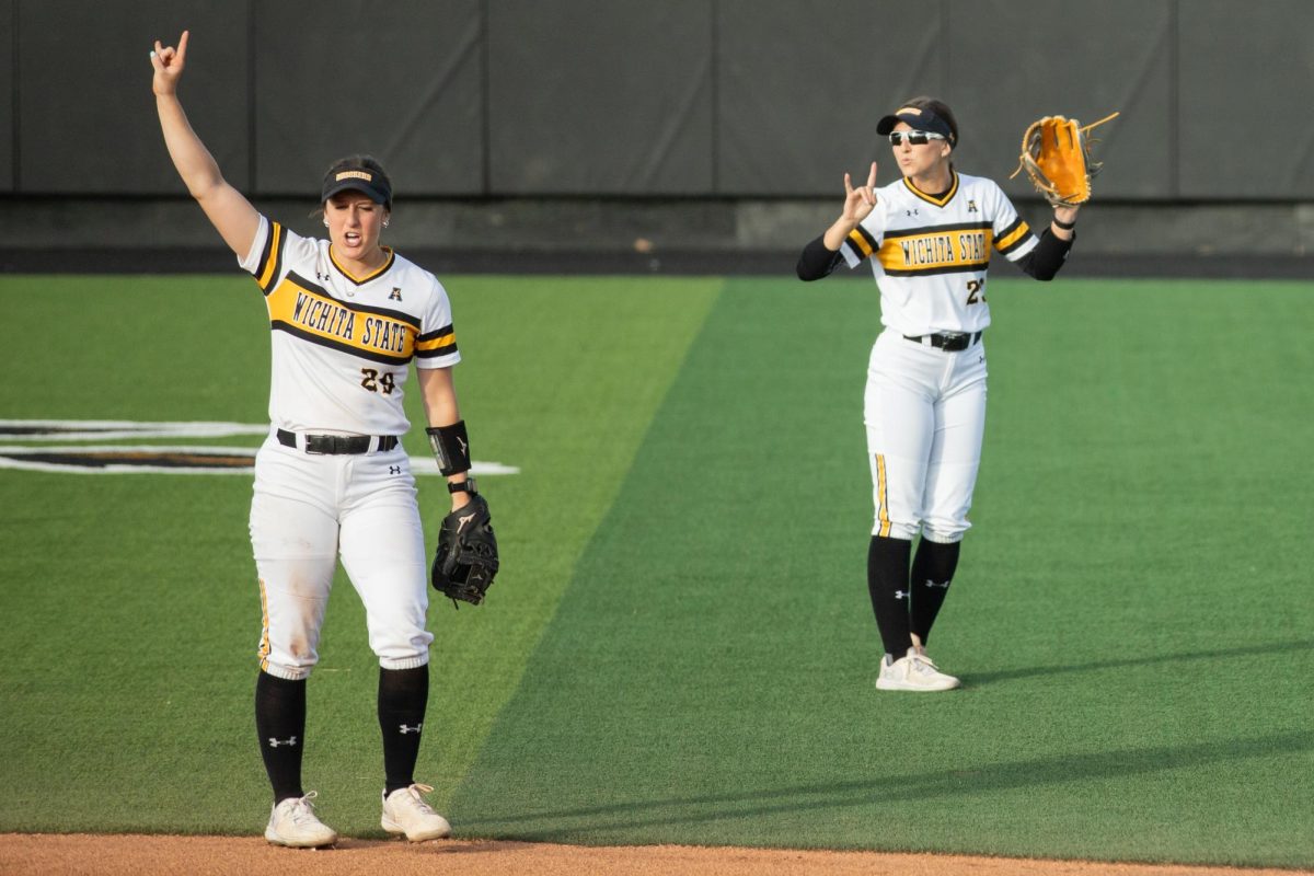 Junior Taylor Sedlacek and grad student Lauren Lucas make a "two outs" hand sign after getting a South Florida player out.