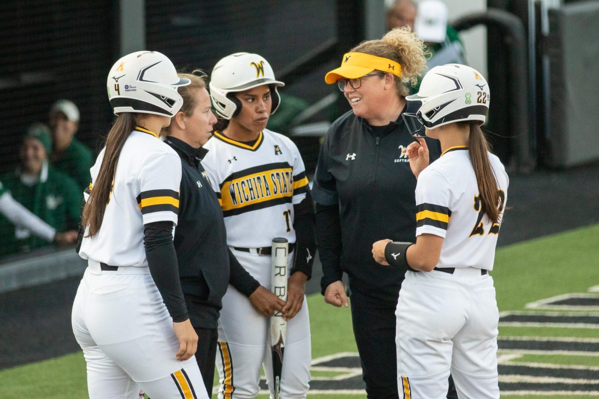 Sofbtall players and coaches gather up and talk between plays against South Florida on March 28.