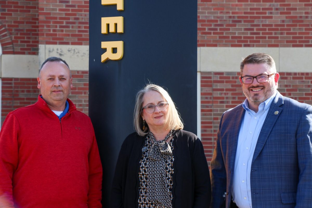 Senior Director of Development for Planned Giving Aaron Winter, Lynette Murphy and Executive Director of Planned Giving Byron Rupp stand in front of the Woodlawn Alumni Foundation. All have included Wichita State in their estate plans.